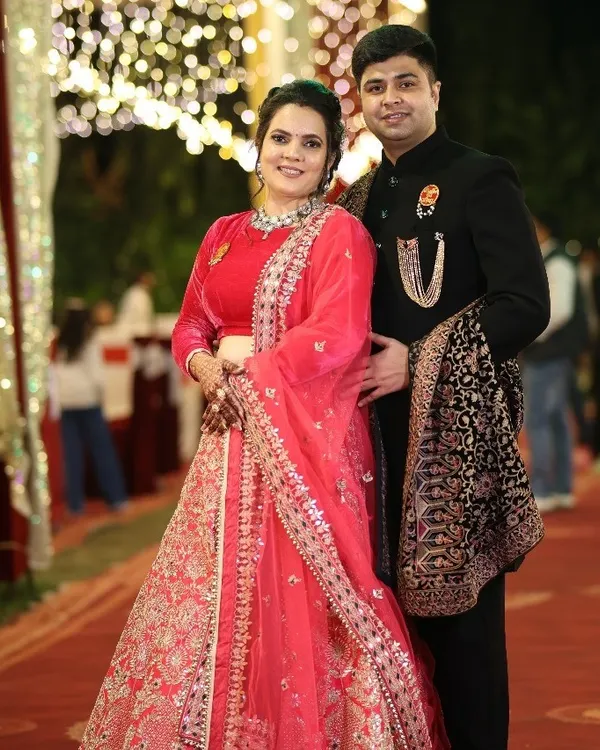 Our clients look radiant at their reception. The groom is wearing a regal black bandhgala with a statement brooch and a beautifully detailed shawl, a perfect choice for an evening of celebration.