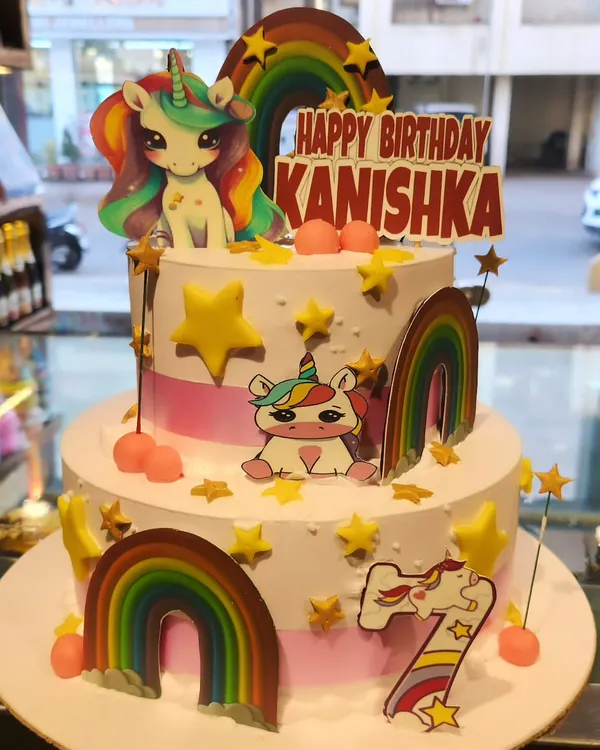 A magical two-tier unicorn birthday cake decorated with rainbows, stars, and adorable unicorn figures. This is one of my most popular designs for kids' parties.