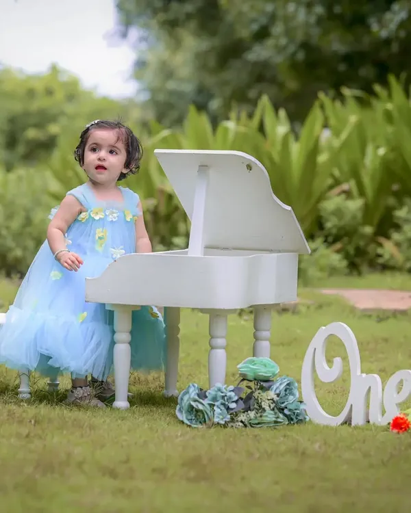 Celebrating a first birthday is a huge milestone. For this outdoor session, we used a mini white piano and a "One" sign to create a sweet, memorable scene for Naira's special day. Milestone photography is about celebrating these precious firsts.