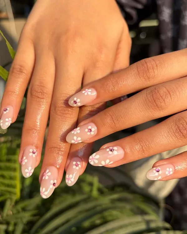 A fresh and delicate look perfect for spring. We hand-painted these tiny white daisies on a sheer nude base, adding a single pink rhinestone in the center of a few flowers for a subtle sparkle.