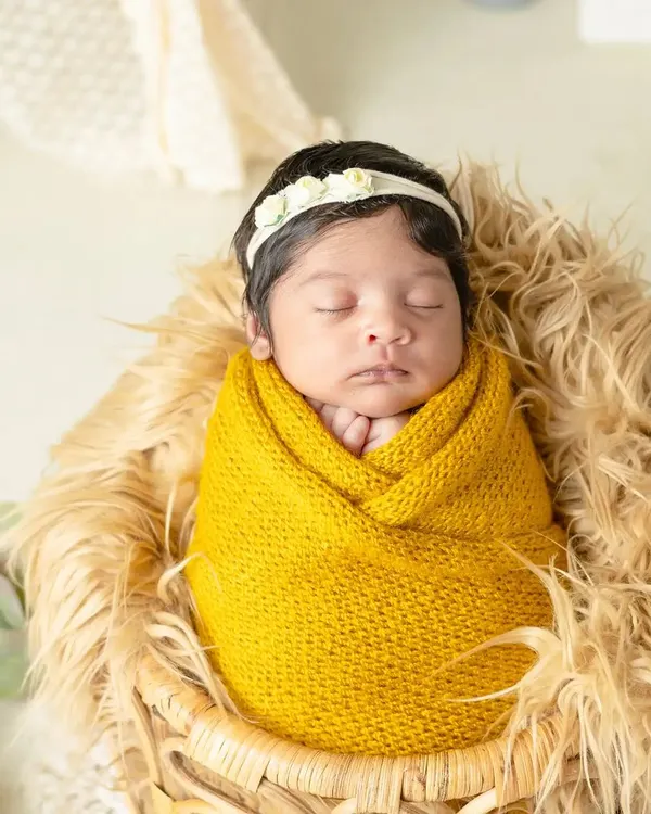 A peaceful newborn wrapped snugly in a yellow knit blanket, dreaming sweetly. I use soft textures and warm colors to create cozy and artistic newborn portraits.