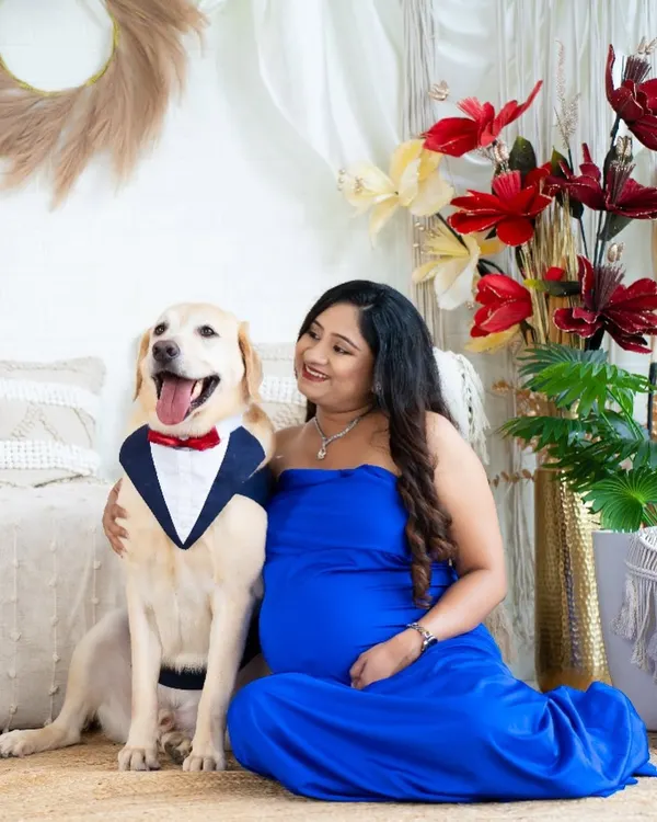 The perfect family portrait, including the fur baby. This adorable shot features an expecting mom with her well-dressed dog, celebrating the expansion of their family.