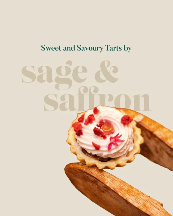 A delicate sweet tart held by wooden tongs, showcasing the perfect swirl of cream and a sprinkle of dried raspberry. This image captures the essence of my sweet and savory tart collection.