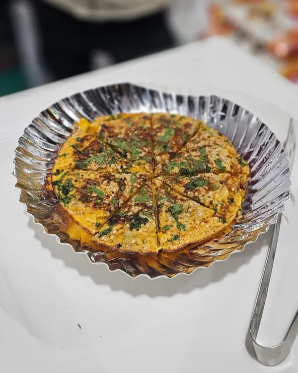 A freshly made pudla, a savory Gujarati pancake, garnished with fresh coriander. This is a popular live counter option that I can arrange for sangeet or mehndi functions.