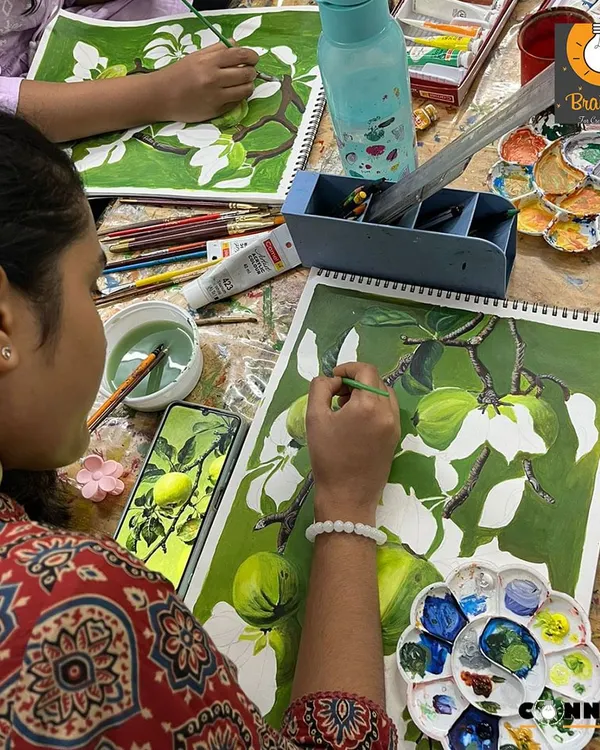 We begin a new project by blocking in the main shapes and colors. This student is using a reference photo to create a realistic composition of fruit on a branch.