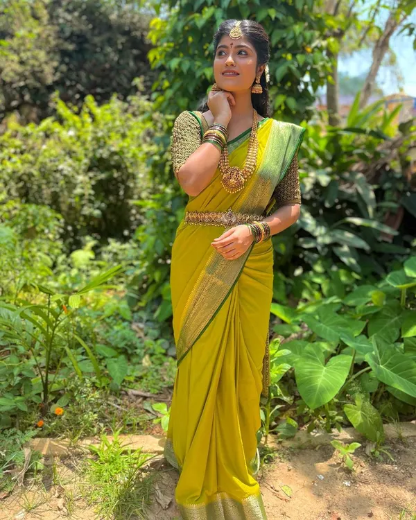 A client looking lovely in a green beaded blouse and lime green saree, perfect for a daytime event.