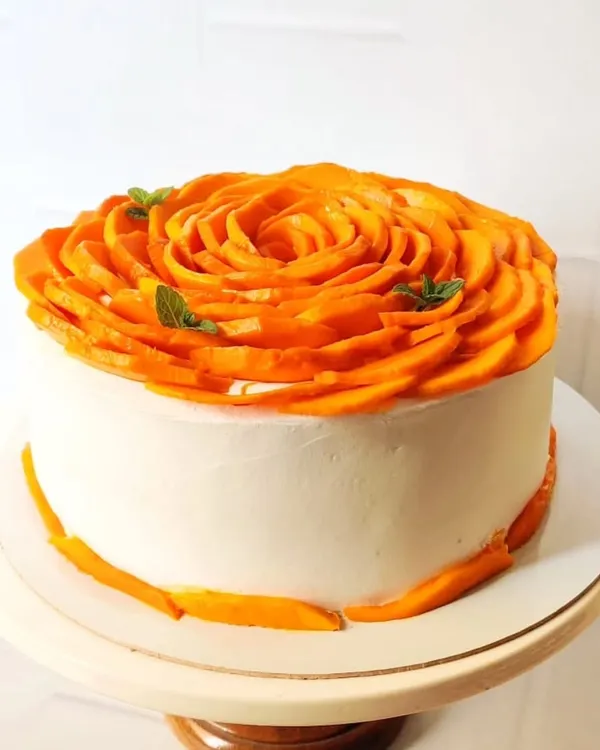 My signature creation, the Alphonso Mango Rose Cake. I meticulously arrange fresh, seasonal mango slices to form an intricate rose. This cake is a testament to my belief that natural ingredients can be the most beautiful decoration.
