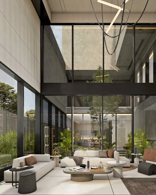 This double-height living space is defined by its connection to the outdoors. Expansive glass walls dissolve the boundary between the interior and the garden, flooding the room with natural light and creating a serene, open atmosphere that embodies our approach to modern residential design.
