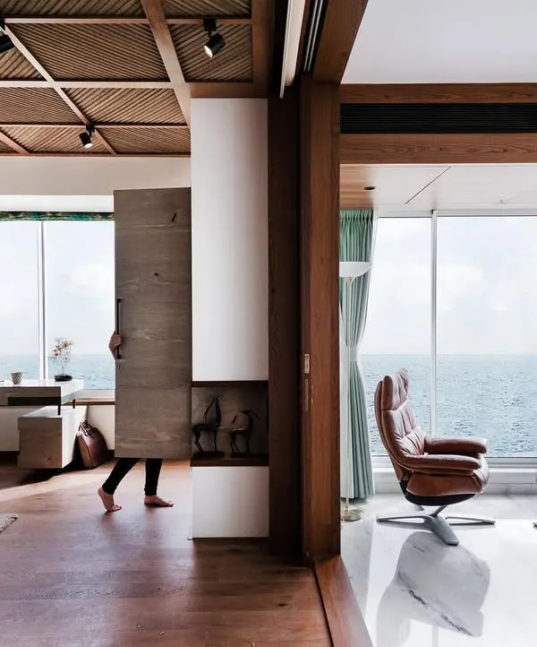 This is what we mean by framing a view. In this Mumbai apartment, the open-plan living space is designed to draw the eye outwards, making the Arabian Sea a permanent part of the home's decor. The design uses flexible partitions and a minimal aesthetic to ensure nothing distracts from the horizon.