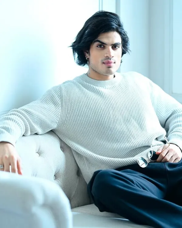 A clean, high-key portrait of a male model on a white sofa. This shot is perfect for a commercial or editorial portfolio, showcasing a relaxed yet sophisticated look.