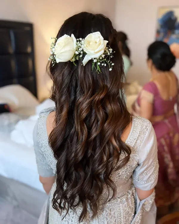 Floral hairstyles are always on trend. This beautiful, soft wavy look with fresh roses was created for a bridesmaid, showcasing our skills in both makeup and hair.