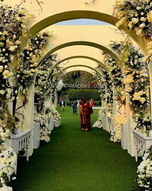 A breathtaking floral archway tunnel creates an unforgettable entrance for guests. We design these immersive experiences to set the tone for your event from the very first step, using thousands of fresh white blooms to craft a pathway that feels like walking through a dream.