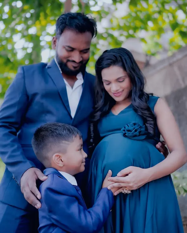 I love capturing the entire family. Here, the older brother looks lovingly at his mom's baby bump. We can provide matching outfits to create a coordinated family look.
