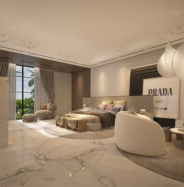 This expansive master suite features polished marble floors and a soft, neutral color palette. We designed a custom room divider to create a separate study nook, and curated the space with unique pendant lights and Prada wall art.