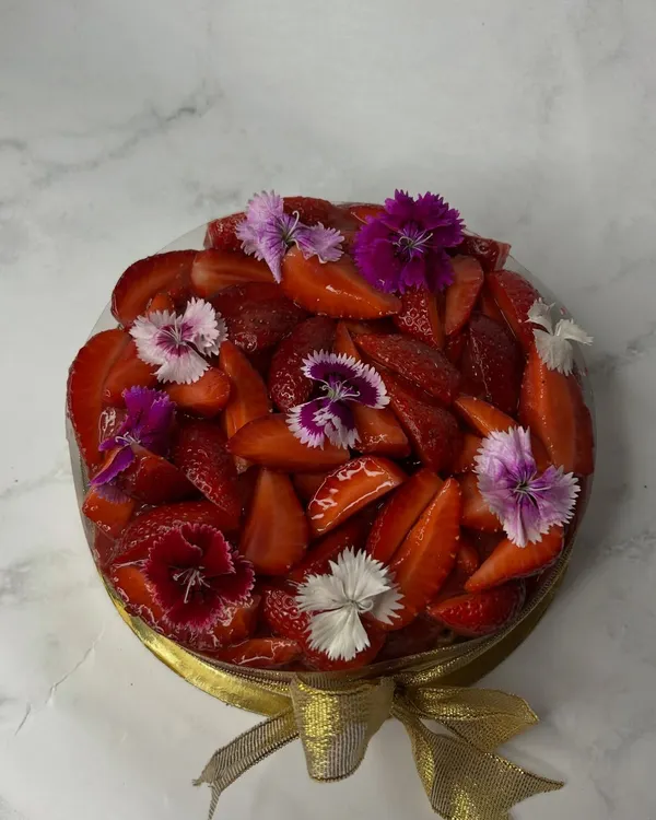 My signature Basque cheesecake gets a seasonal makeover. I top it with a generous layer of house-made strawberry compote, fresh strawberries, and delicate edible flowers. It's available in both zero-sugar and regular versions for your next celebration.