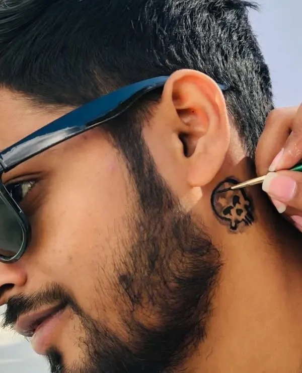 Getting this client ready with a cool skull temporary tattoo behind the ear. It's a small detail that adds a lot of edge to a look.