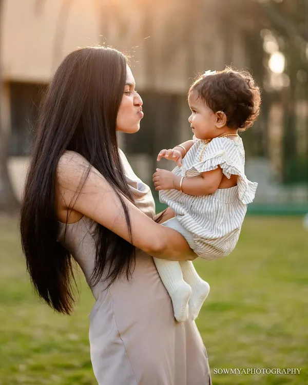 A sweet outdoor portrait of a mother making a kissy face at her baby. We focus on capturing these simple, loving gestures that beautifully illustrate the mother-daughter bond.