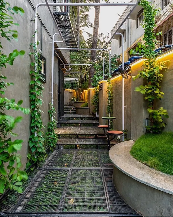We transformed this narrow passage in Juhu into a vibrant green pocket for Naturals NOW. A unique steel mesh floor allows plants to grow underneath, creating a multi-layered garden experience and proving that even the tightest urban settings can become lush oases.