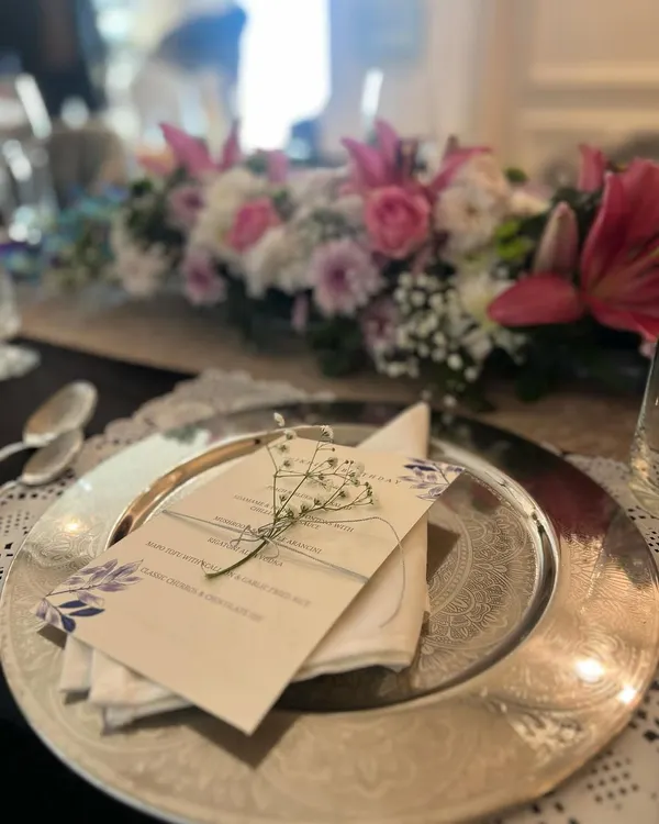 The table is set for our first-ever sit-down lunch. Each place setting includes a printed menu and a sprig of baby's breath, small details that elevate the dining experience.