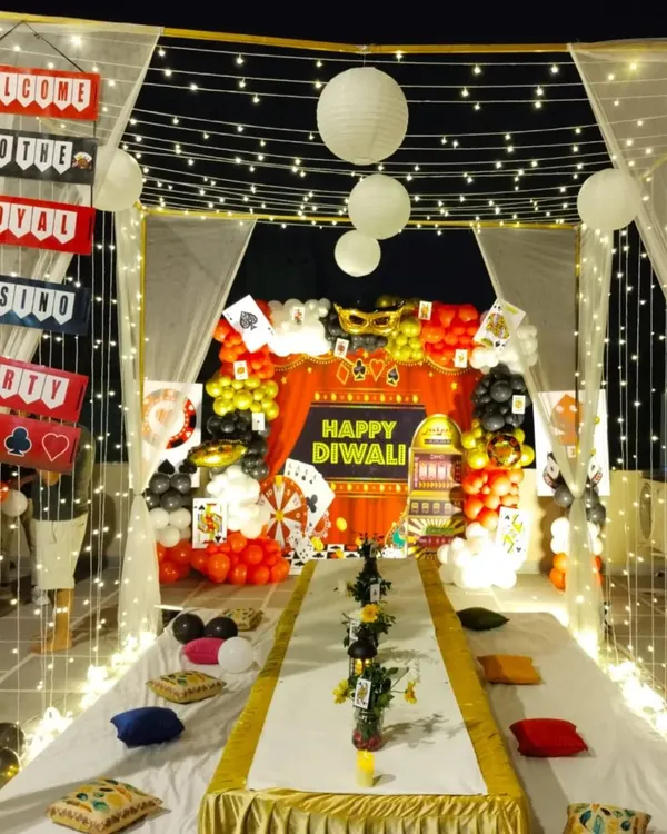A complete casino-themed Diwali party setup on a terrace. We created a canopy with fairy lights and drapes, with a themed backdrop, low seating arrangement, and custom props.
