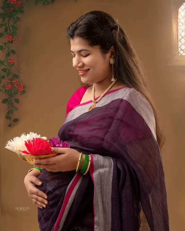 This portrait captures the essence of a traditional Maharashtrian baby shower, or dohale jevan. The mother-to-be, dressed in a beautiful saree, holds a plate of flowers, symbolizing blessings and fertility.