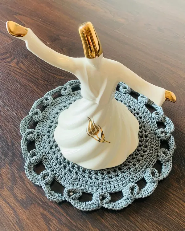This grey doily features a beautiful, intricate openwork border. It's a classy and elegant piece that adds a touch of sophistication to any surface.