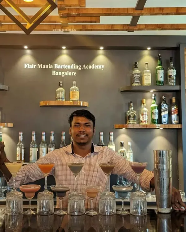 One of our skilled bartenders proudly displaying a full bar of colorful cocktails he's prepared.