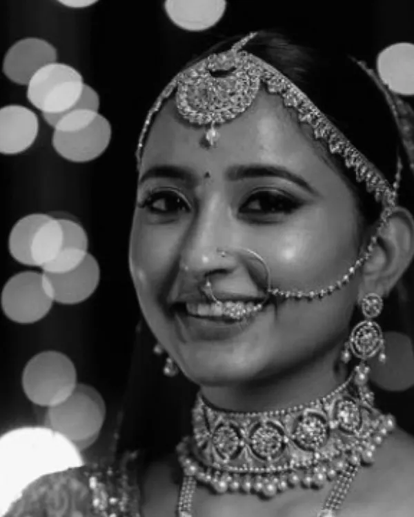 A close-up of our bride Chandrika, radiating happiness. Her complete bridal set, including the choker, maang tikka, and nath, was custom-designed to harmonize with her traditional red lehenga.