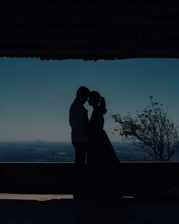 A beautiful silhouette of a couple against the vast sky. This artistic shot captures a feeling of intimacy and endless possibilities.