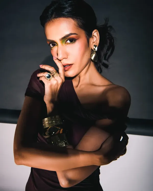 This shot is all about the power of shadow and light. I used a single, hard light source to create dramatic contrast, sculpting the model's features and highlighting the bold, colorful eye makeup. The pose is confident and confrontational, perfect for a high-fashion editorial.