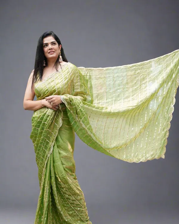 A full view of our lightweight and pocket-friendly party-wear organza tissue saree in a lovely lime green. The delicate sequins and scallop edging add just the right amount of glam.