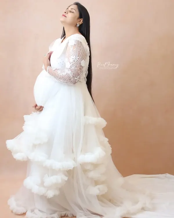Feel serene and beautiful in this white ruffle maternity gown. It features delicate lace sleeves and a long train, all made with comfortable, skin-friendly fabric. Home delivery and trials are available across Mumbai.