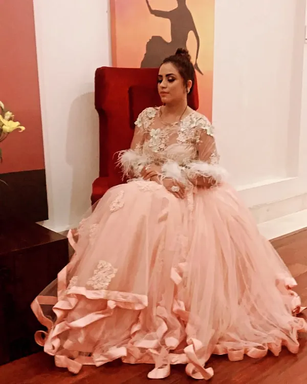 For a truly grand occasion like a wedding reception or cocktail event, a gown like this peach tulle creation with feather details makes a breathtaking statement. I help clients find silhouettes that feel both regal and personal.