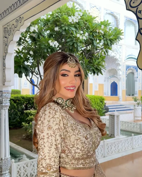 A radiant smile in a golden embroidered lehenga. I styled this look for a daytime palace wedding, pairing the outfit with a beautiful maang tikka and a contrasting green choker.