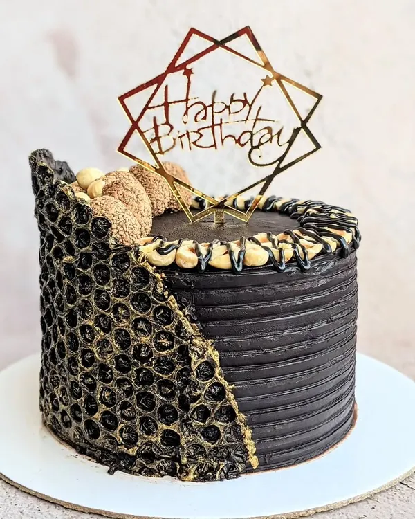 Chocolate is happiness you can eat. This decadent Ferrero Rocher cake is covered in dark chocolate ganache and features a unique chocolate collar made using a bubble wrap mold for texture.