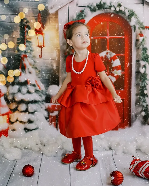 Believing in the magic of the season. This little girl in her beautiful red dress is ready for Christmas. These photos become treasured memories long after the season passes.