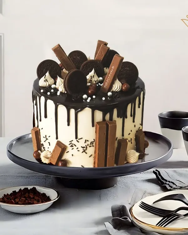 A true chocolate lover's paradise. This cake is loaded with KitKats, Oreos, and chocolate balls, all brought together with a rich, dark chocolate drip over a smooth buttercream finish.