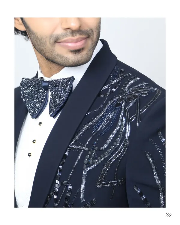 It's all in the details. A close-up of the hand-beaded bow tie and the intricate silver embroidery on our navy tuxedo jacket. This is the level of craftsmanship that sets my rental collection apart.
