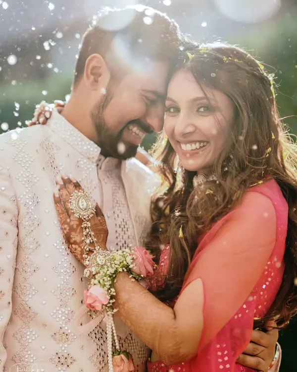 Bathed in golden light and showered with petals, this candid portrait captures the pure, unscripted joy between a couple. This is the kind of authentic emotion we love to photograph.