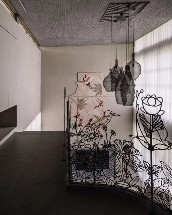 This custom metal railing tells a story of Ahmedabad's seasonal blooms. The intricate, laser-cut design features flowers and birds, transforming a safety feature into a delicate piece of line art that spans the corridors of the villa.