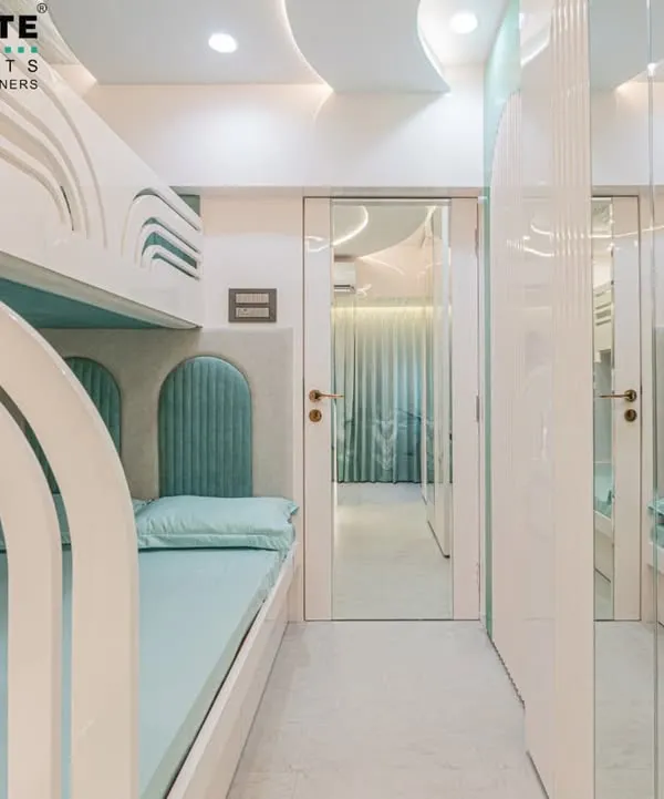 A unique kids' room designed to maximize space. This room features custom-built bunk beds with wave-like cutouts and individual headboards, creating cozy, personal nooks for each child. The mirrored wardrobe doors make the narrow room feel much larger.