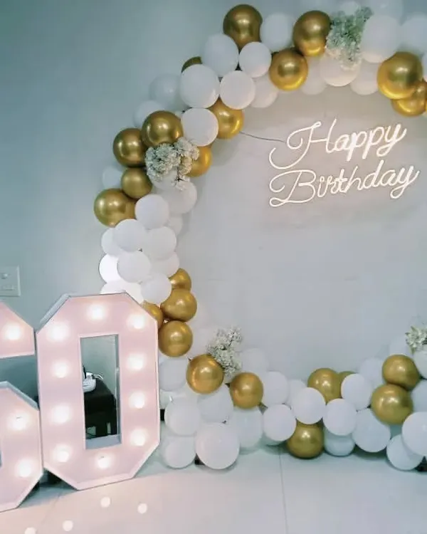 This is the kind of setup I love creating for major milestones. For this 60th birthday, I designed an elegant circular backdrop with white and chrome gold balloons, accented with delicate white flowers. The large, illuminated marquee numbers add a personalized and glamorous touch, creating the perfect photo opportunity.