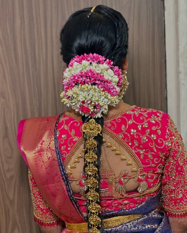 The quintessential South Indian bridal hairstyle. This close-up shows the intricate temple jewelry and the beautiful gajra bun, which are key elements of the look.