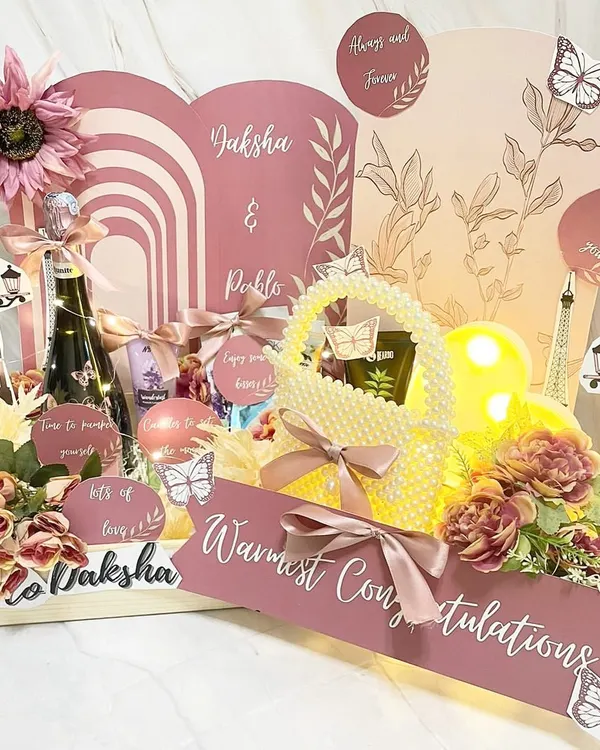 This is what we mean by a story wrapped up. We created this fully customized hamper for a bride and groom to be, complete with personalized illustrations, fairy lights, and their favorite things to celebrate their journey.