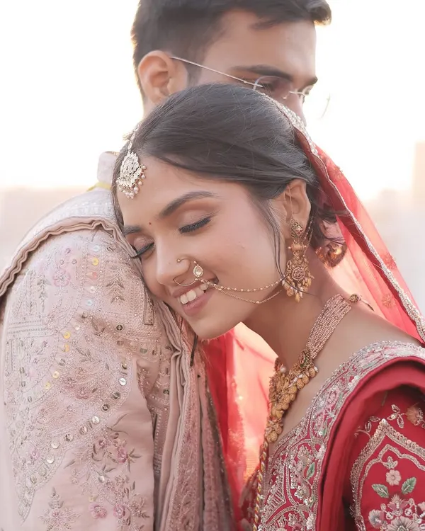 A tender moment between the couple. The bride's makeup is soft and romantic, designed to look beautiful up close and enhance the emotional connection in the photograph. This is a classic shot from a wedding day photoshoot.
