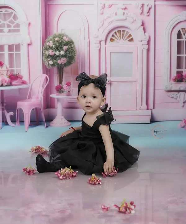 A quiet moment in her pink dollhouse world. This shot captures the dreamy, imaginative quality of our themed sessions for toddlers.