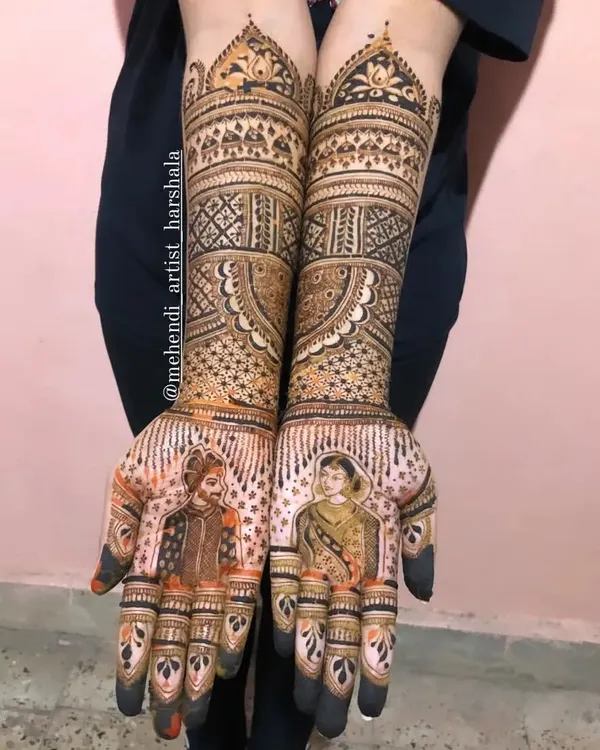 A complete bridal mehendi with detailed portraits of a Maharashtrian couple. The design extends to the elbows, featuring traditional motifs that complement the bride and groom figures on the palms.