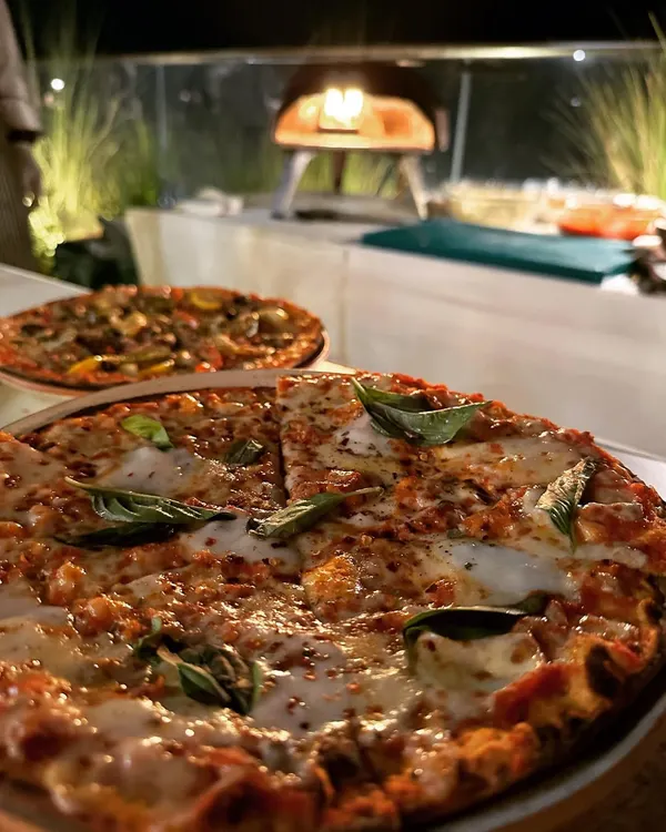 This is what we live for: the sizzle of a wood-fired Ooni oven, the aroma of fresh basil, and a perfectly baked pizza ready to be devoured. We bring the complete pizzeria experience to your party, creating delicious, authentic Tuscan-style pizzas right before your eyes.