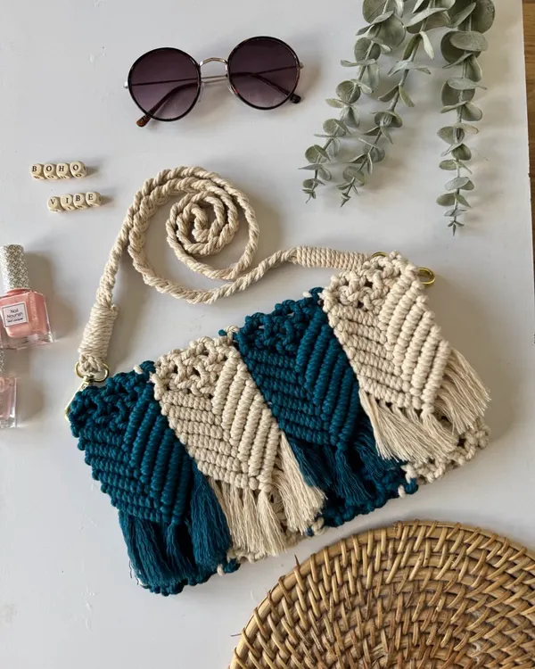 This custom macrame sling bag features a two-tone chevron pattern and a hand-knotted strap. It's made from soft but durable cotton cord, perfect for carrying your essentials with boho flair.