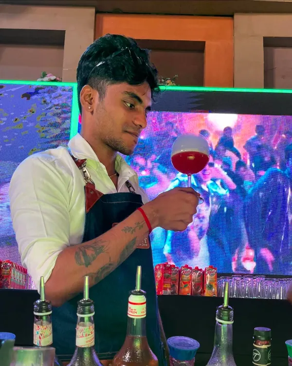 The 'Bubble Pop' cocktail is an interactive experience. Here, our bartender presents the finished drink, where a fragrant smoke bubble sits atop a vibrant red cocktail.
